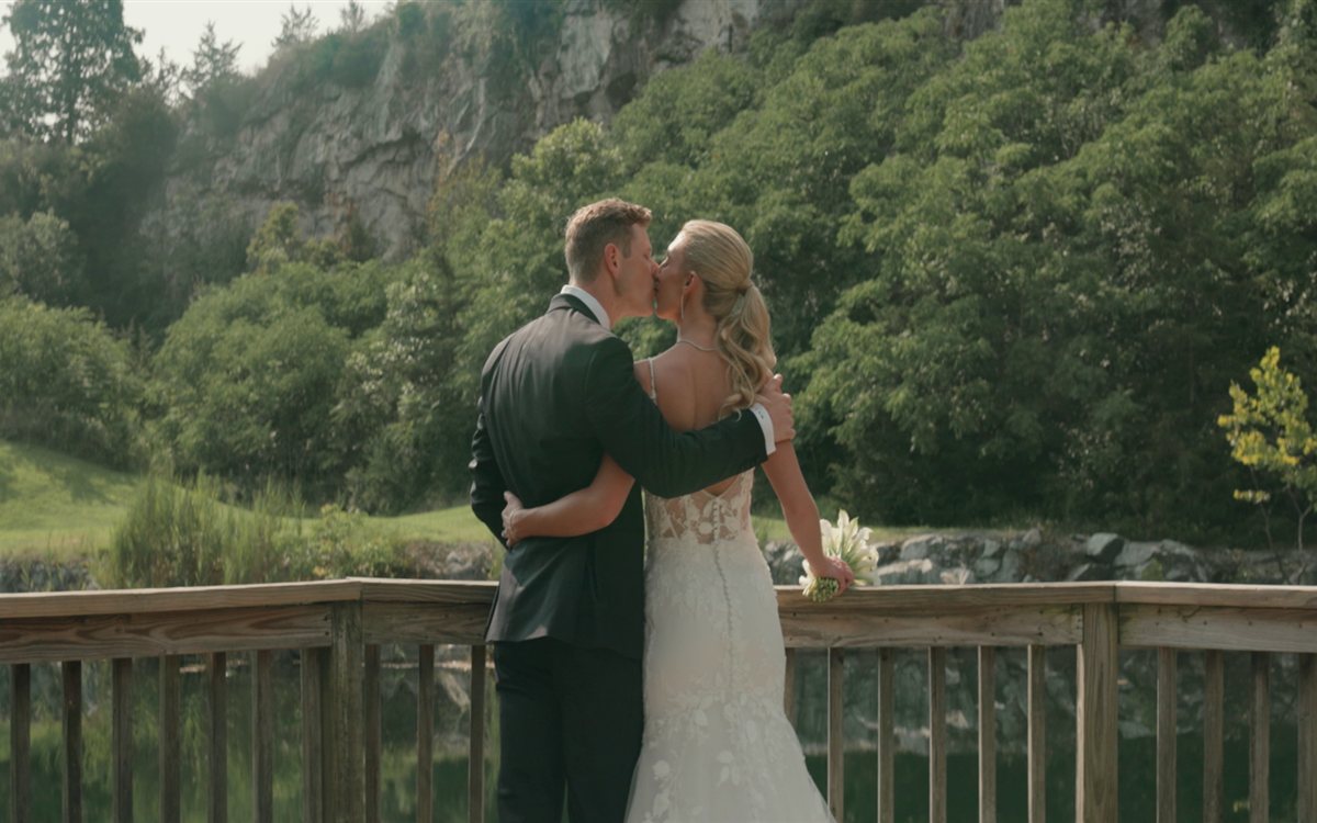Mike and Sam kissing on the quarry bridge at their Crystal Springs Resort wedding