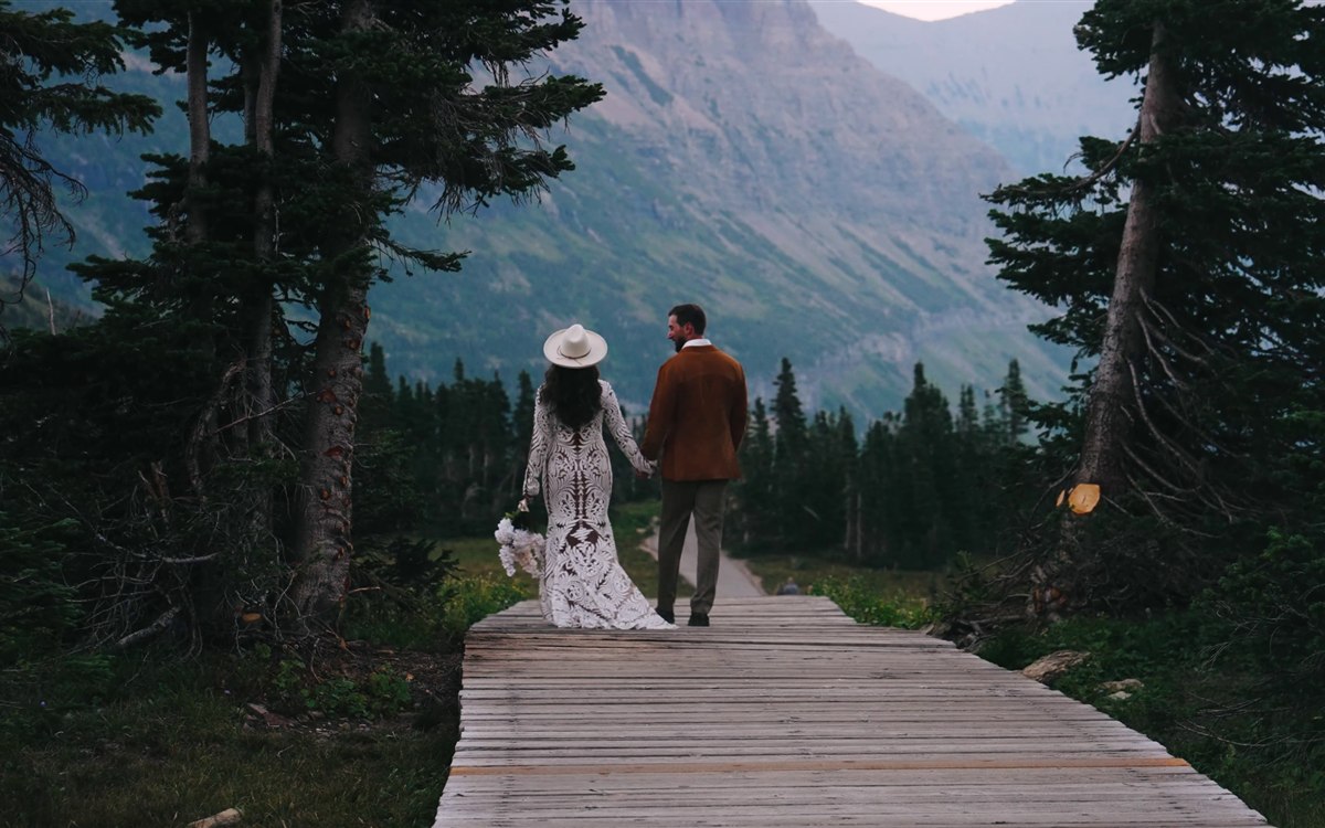 Michelle and Adam walking the high-country boardwalk trail at their Glacier National Park wedding