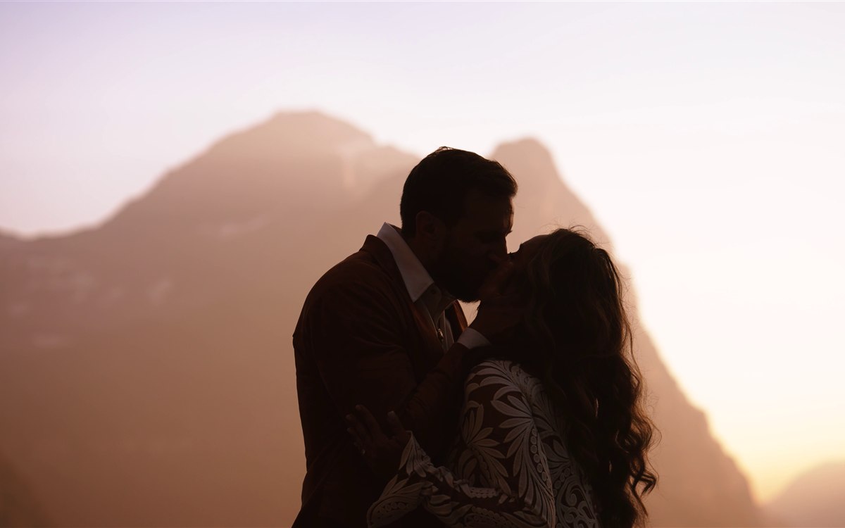 Glacier National Park Wedding Videography bride and groom kissing at sunset